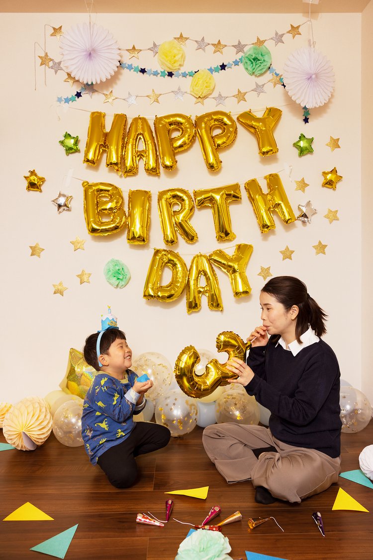 誕生日の飾り付けを親子で楽しむ女性